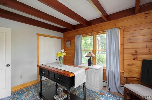 dining area with a baseboard radiator and beam ceiling