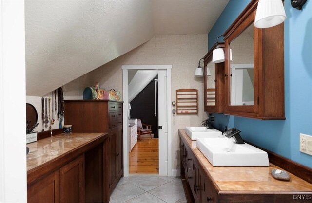 bathroom featuring wood-type flooring, vaulted ceiling, and vanity