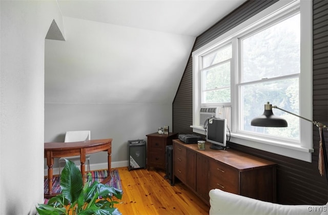 office space with cooling unit, vaulted ceiling, and light hardwood / wood-style flooring