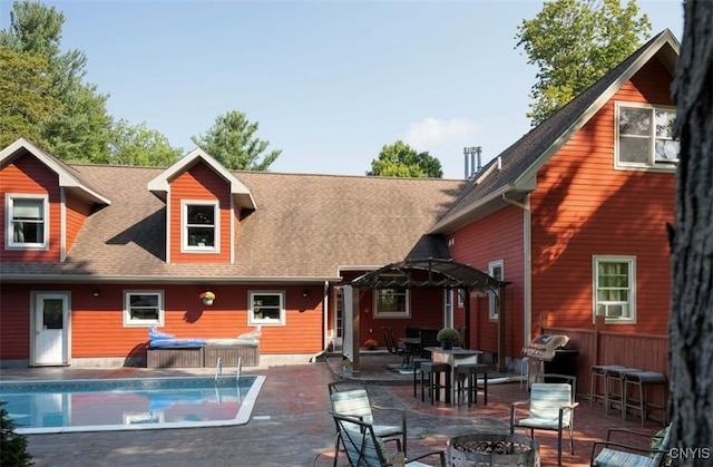 back of property with a fire pit and a patio area