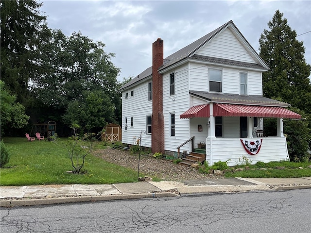 view of front of home with a storage unit and a front lawn