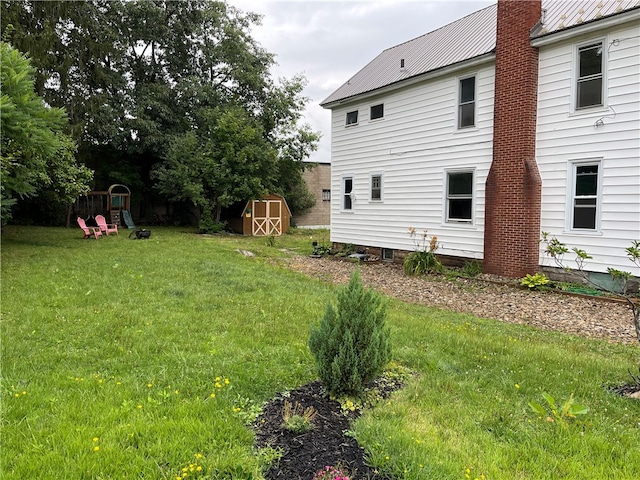 view of yard featuring a playground and a storage shed