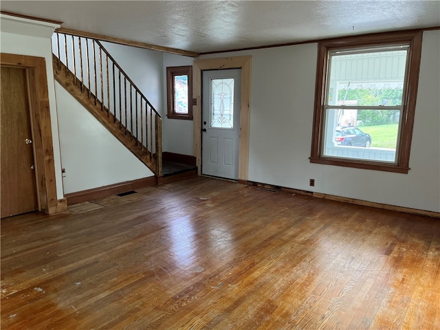 entrance foyer with hardwood / wood-style floors, a textured ceiling, and a healthy amount of sunlight