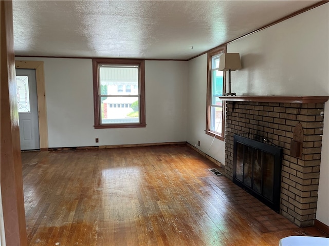 unfurnished living room featuring a fireplace, plenty of natural light, and hardwood / wood-style floors