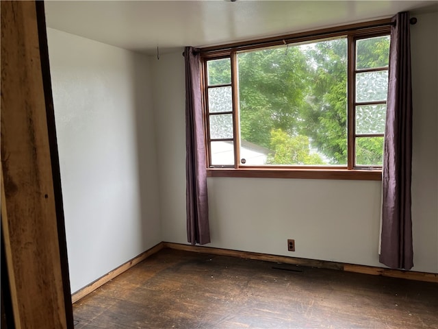 empty room featuring dark hardwood / wood-style flooring and a healthy amount of sunlight