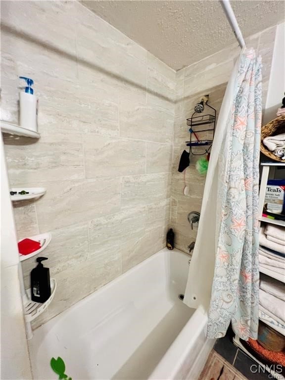 bathroom featuring a textured ceiling, tile patterned flooring, and shower / bath combo