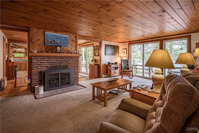 carpeted living room with wood ceiling, a wealth of natural light, and a brick fireplace