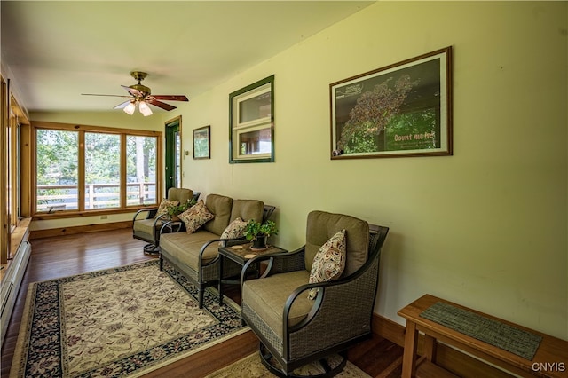 living room with wood-type flooring, a baseboard radiator, and ceiling fan