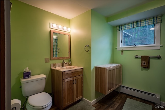 bathroom with vanity, toilet, wood-type flooring, and a baseboard radiator