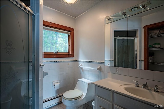 full bathroom with a stall shower, a baseboard radiator, a textured ceiling, and vanity