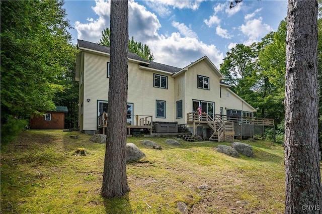 rear view of property with an outbuilding, a yard, and a wooden deck