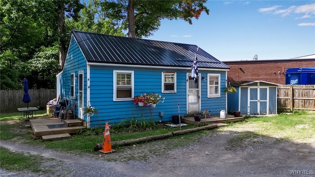 bungalow-style house with a storage unit