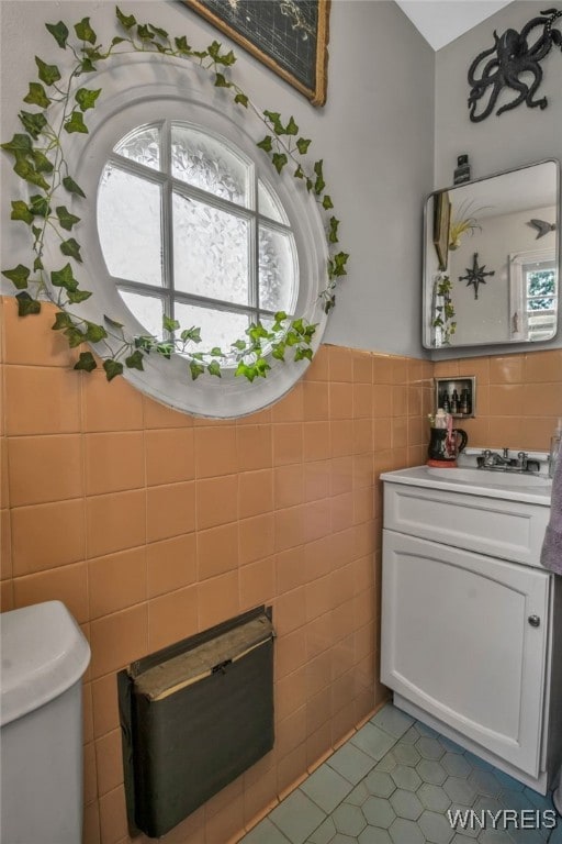 bathroom with vanity, tile walls, toilet, and tile patterned flooring