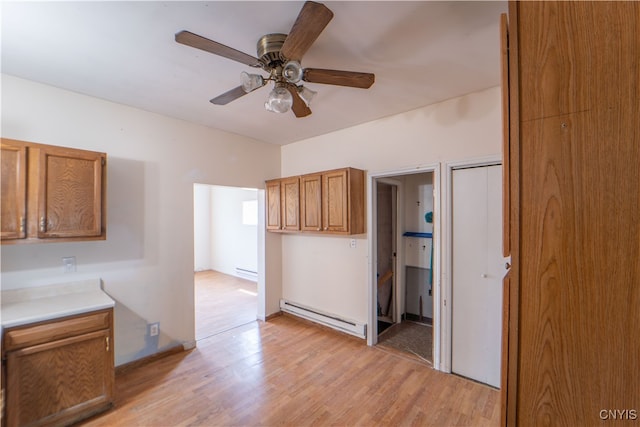 kitchen with brown cabinets, light countertops, baseboard heating, a baseboard heating unit, and light wood-style floors