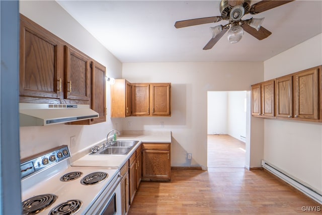 kitchen with electric stove, a baseboard radiator, light countertops, under cabinet range hood, and a sink