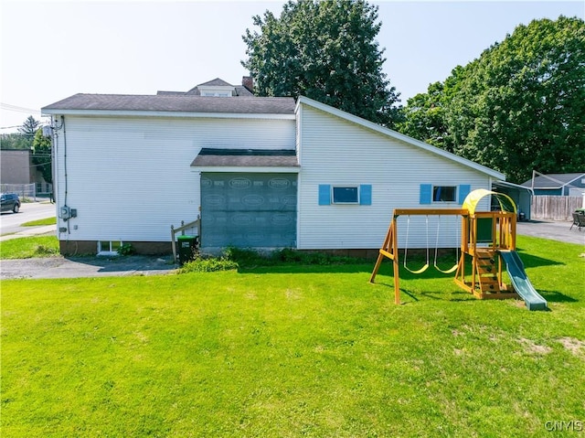 view of side of home featuring a playground and a lawn