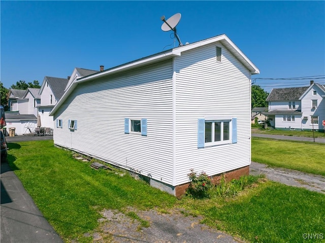 view of side of home with a yard and a residential view