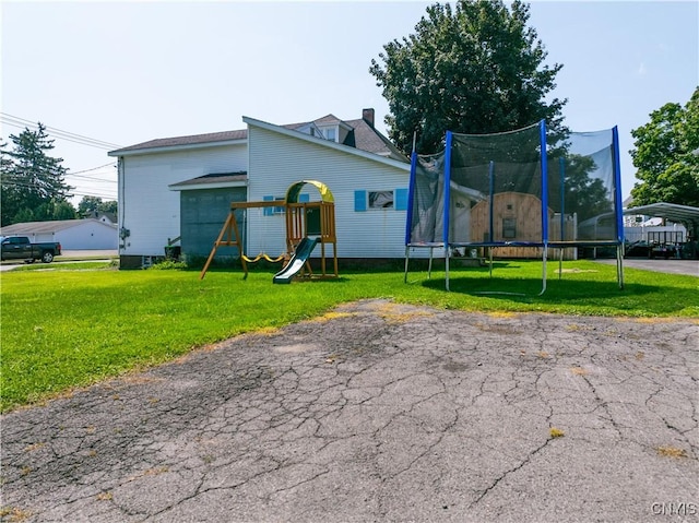 exterior space with a trampoline and a yard