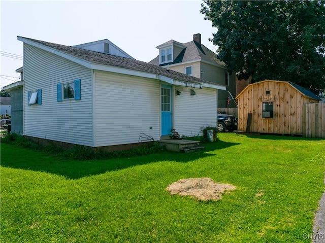 rear view of property with an outbuilding and a yard