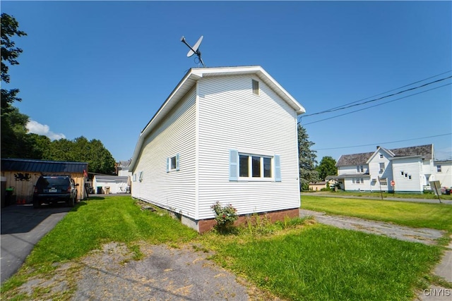 view of home's exterior with a yard and driveway