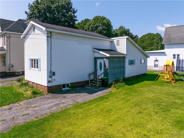 view of front of house featuring entry steps, a playground, and a front lawn