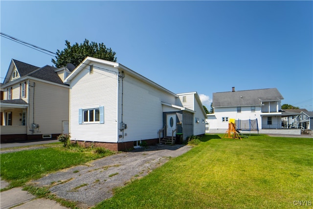 view of side of home with entry steps and a yard