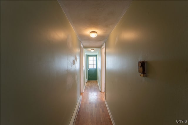 corridor featuring wood finished floors and baseboards