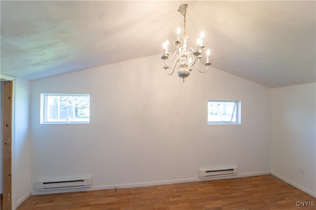 spare room featuring a baseboard heating unit, lofted ceiling, and a healthy amount of sunlight