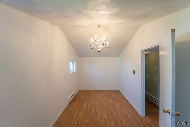 unfurnished room featuring a baseboard heating unit, wood finished floors, baseboards, vaulted ceiling, and baseboard heating