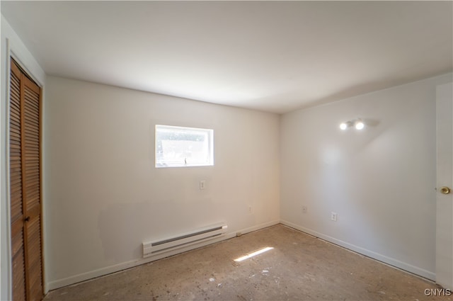 empty room with a baseboard heating unit and baseboards