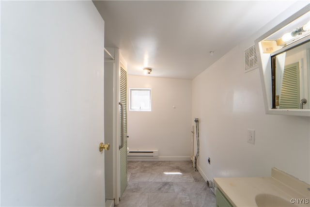 bathroom with a baseboard radiator, visible vents, vanity, and baseboards