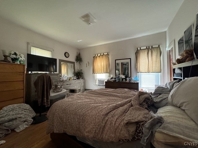 bedroom with hardwood / wood-style floors and cooling unit