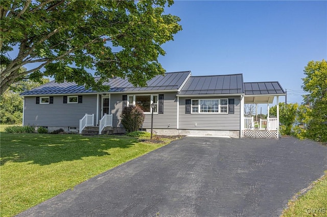 single story home with aphalt driveway, a front yard, a standing seam roof, and metal roof