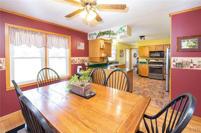 dining space with ornamental molding, a ceiling fan, and baseboards