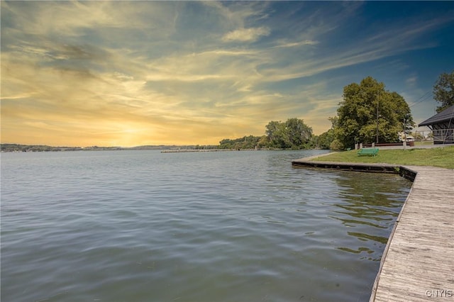 view of dock featuring a water view and a lawn