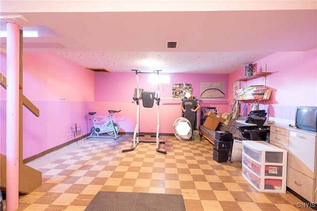 exercise room featuring light floors