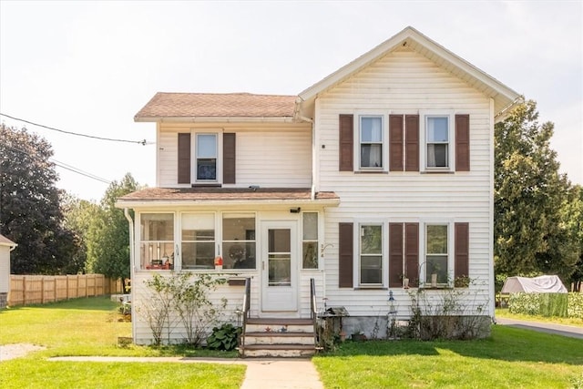 view of front of property with entry steps, a front yard, and fence