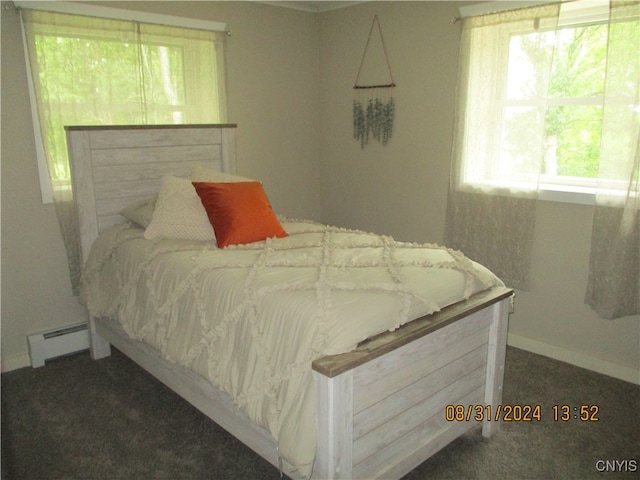 bedroom featuring a baseboard heating unit and dark carpet