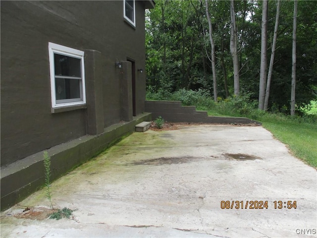 view of side of property featuring stucco siding and a patio