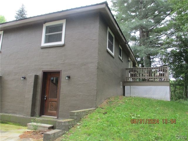 exterior space featuring a wooden deck and a front lawn