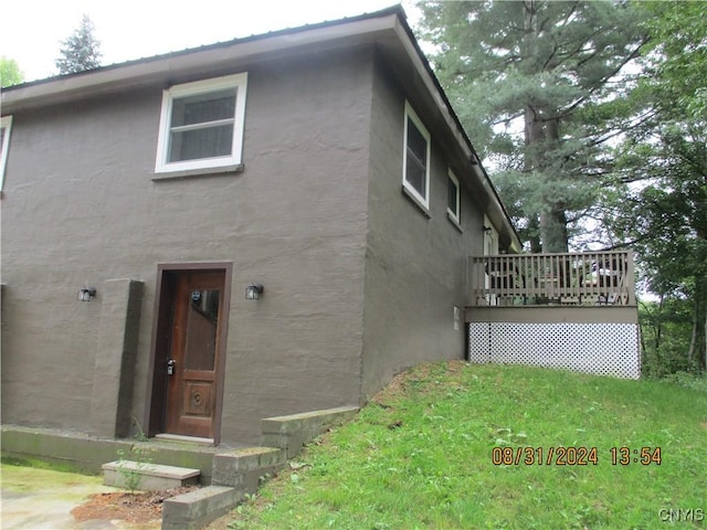 view of property exterior with stucco siding and a deck