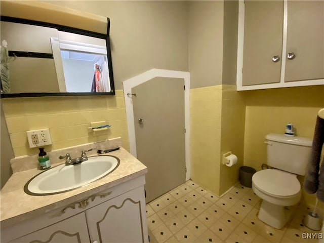 bathroom with backsplash, tile patterned floors, toilet, tile walls, and vanity