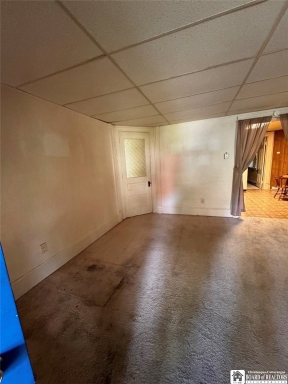 carpeted empty room featuring a paneled ceiling