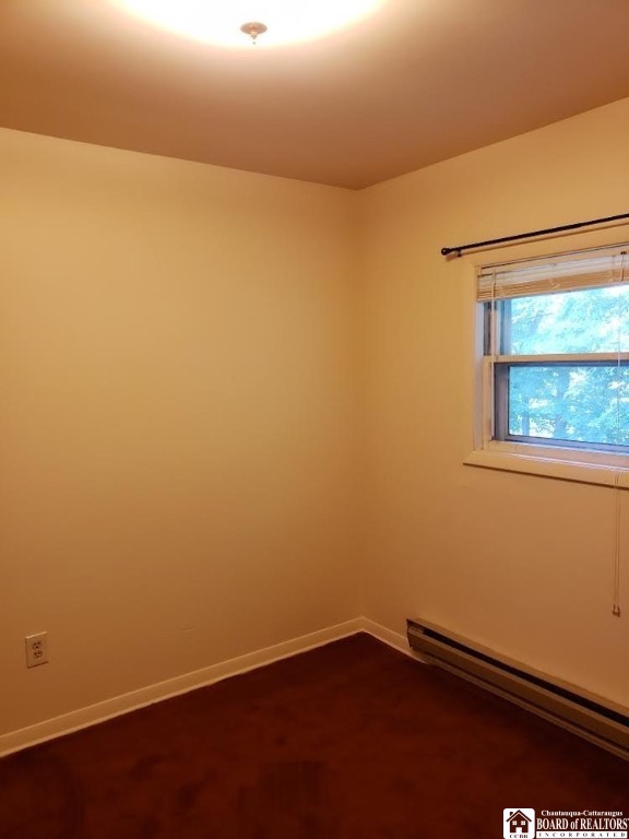 carpeted empty room with baseboard heating