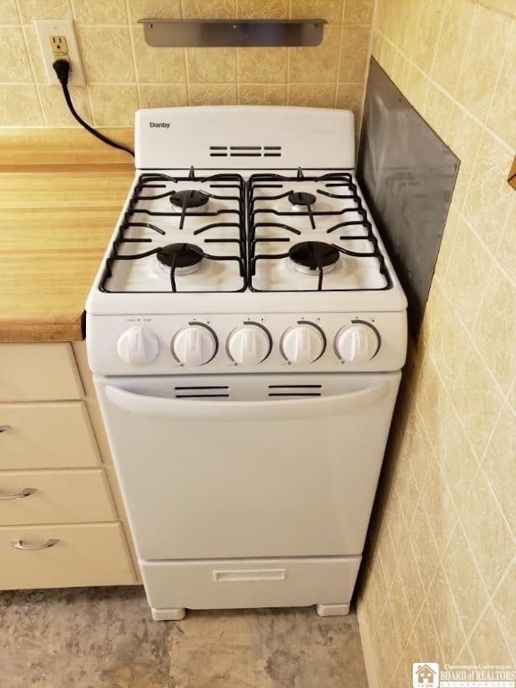 room details with tile patterned flooring and white range with gas cooktop