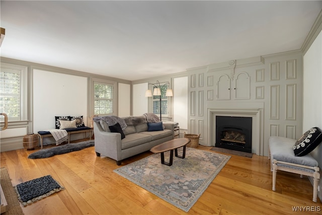 living room with plenty of natural light, crown molding, and light hardwood / wood-style flooring