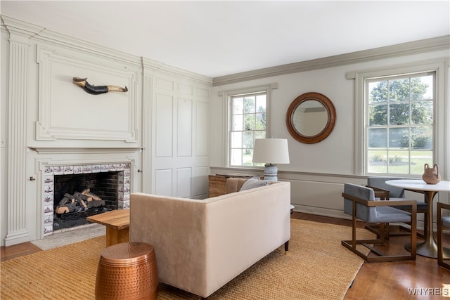 living room featuring a wealth of natural light, light hardwood / wood-style flooring, and crown molding