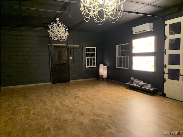 unfurnished living room featuring a chandelier, wood-type flooring, and a wall mounted air conditioner