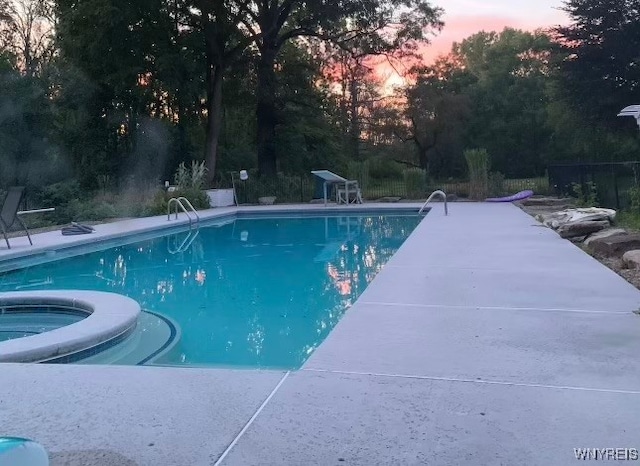 view of pool at dusk