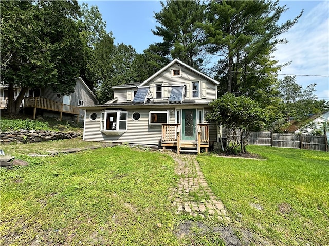 view of front of house with a wooden deck and a front lawn